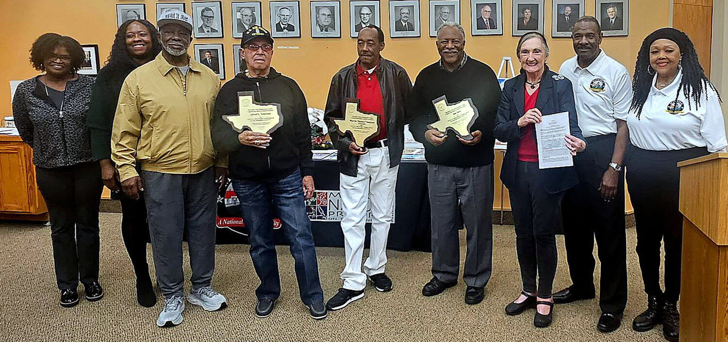 Several former McFarland Bears were on hand for the proclamation of McFarland Bears Athletes Day in Mineola Monday, Nov. 27. From left, Crystal Walton representing Eddie Walton, TaShara Stephens representing Darwin Stephens, Cecil Tuck, Alfred Tennyson, Cedric Sampson representing Marvin “Duckey” Sampson, Joe Tave, Mayor Pro Tem Sue Jones and council members Mitch Tuck and Cassandra Sampson.